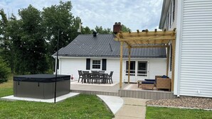 A backyard with a hot tub, patio furniture, and a covered seating area. - The Claxton house a Greenup county Historic home built in 1864 with hot tub (Greenup)