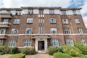 A multi-story brick building with a central entrance labeled 'Windsor Court.' - Spacious & Stylish 4-Bed Flat in Golders Green - Pass the Keys (London)