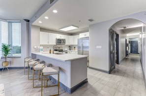 A modern kitchen with a central island, bar stools, and a view of the city. - Spacious 2-bedroom condo with Lakeview in superb Orlando location Close 2 Disney (Orlando)