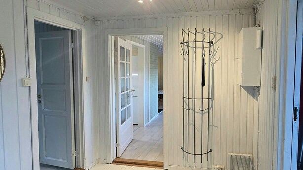 A room with a large woven rug, a bench, and a metal rack against the wall. - Cabin with views over Hvaler archipelago (Gamle Frederikstad)