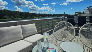 A deck with a sofa, two chairs, a table, and a book titled 'Donald Duck.' - Cabin with views over Hvaler archipelago (Gamle Frederikstad)