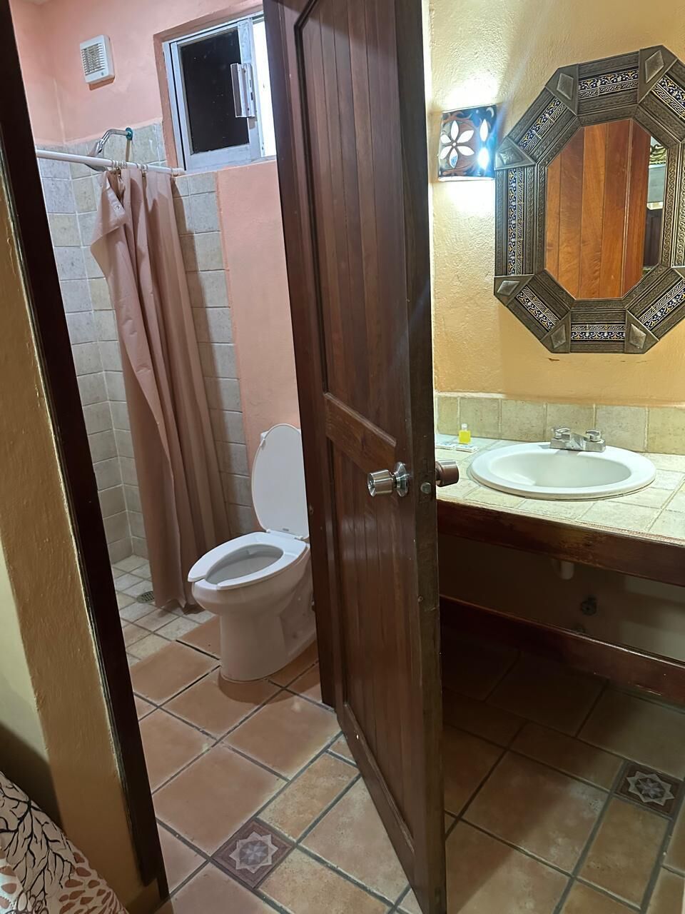 Une salle de bain comprenant des toilettes, un lavabo et un espace douche.