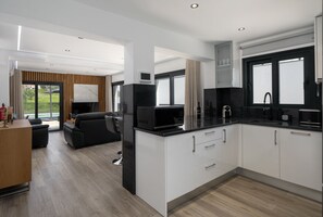 Eine moderne Küche mit schwarzer Arbeitsplatte, weißen Schränken und einer eingebauten Mikrowelle.