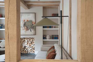 Eine gemütliche Leseecke mit einer Couch, einem Bücherregal und einem Kamin.
