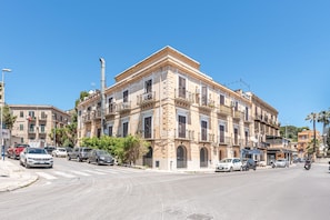 A multi-story building with balconies, parked cars, and a clear sky. - Igiea Florio Sea View by Wonderful Italy (Palermo)