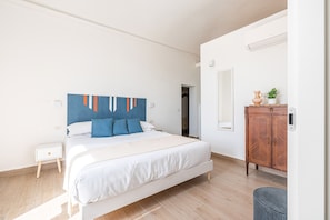 A bedroom with a bed, a nightstand, a dresser, and a mirror. - Igiea Florio Sea View by Wonderful Italy (Palermo)