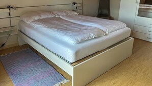 Una camera da letto moderna con un letto, un comodino e un'armadio.