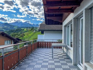 A balcony with a tiled floor, a table, and a view of a mountainous landscape. - Domizil Seeidyll Appartement/Fewo Appartement/Fewo by Interhome (Spiez)