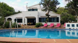 A two-story building with a swimming pool, outdoor seating, and a covered patio. - Holiday Home 'Casa En El Campo Con Vistas Al Mar' with Private Pool, Private Terrace and Wi-Fi (Maó)