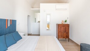 Ein Schlafzimmer mit Bett, Kleiderschrank, Spiegel und Fenster.