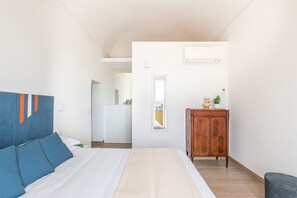 A bedroom with a bed, a wardrobe, a mirror, and a window. - Igiea Florio Sea View by Wonderful Italy (Palermo)