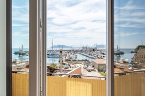 Ein Yachthafen mit vor Anker liegenden Booten, ein klarer Himmel und Blick auf das Meer.