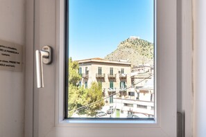 Blick aus dem Fenster auf ein Gebäude mit einem Berg im Hintergrund.