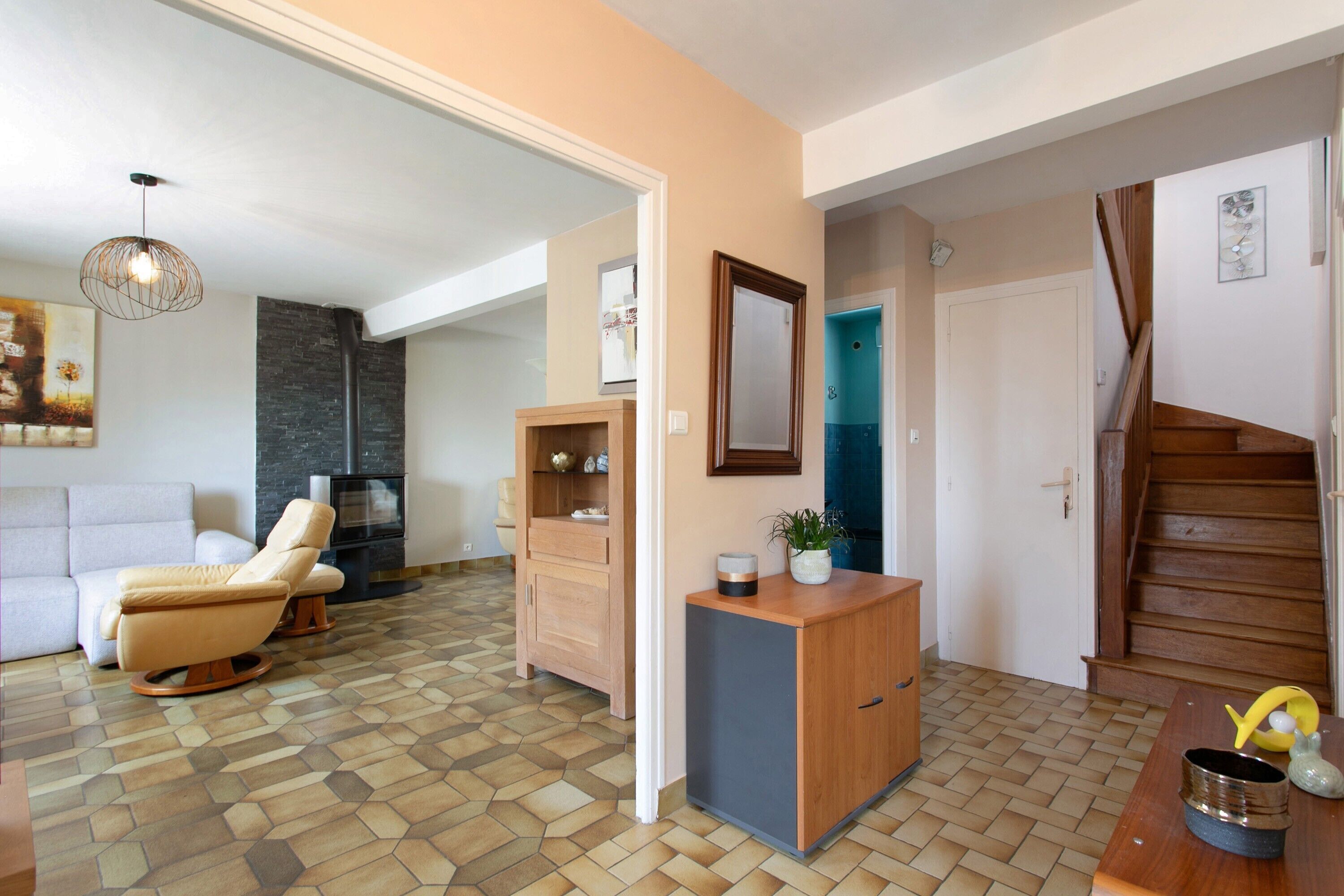 Una sala moderna con sofá, chimenea y comedor con un aparador de madera.