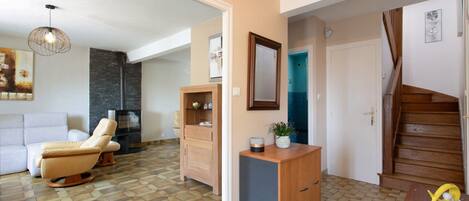 Una sala moderna con sofá, chimenea y comedor con un aparador de madera.