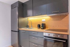 Eine moderne Küche mit einem Edelstahl-Kühlschrank, einer doppelten Spüle und einem eingebauten Backofen.