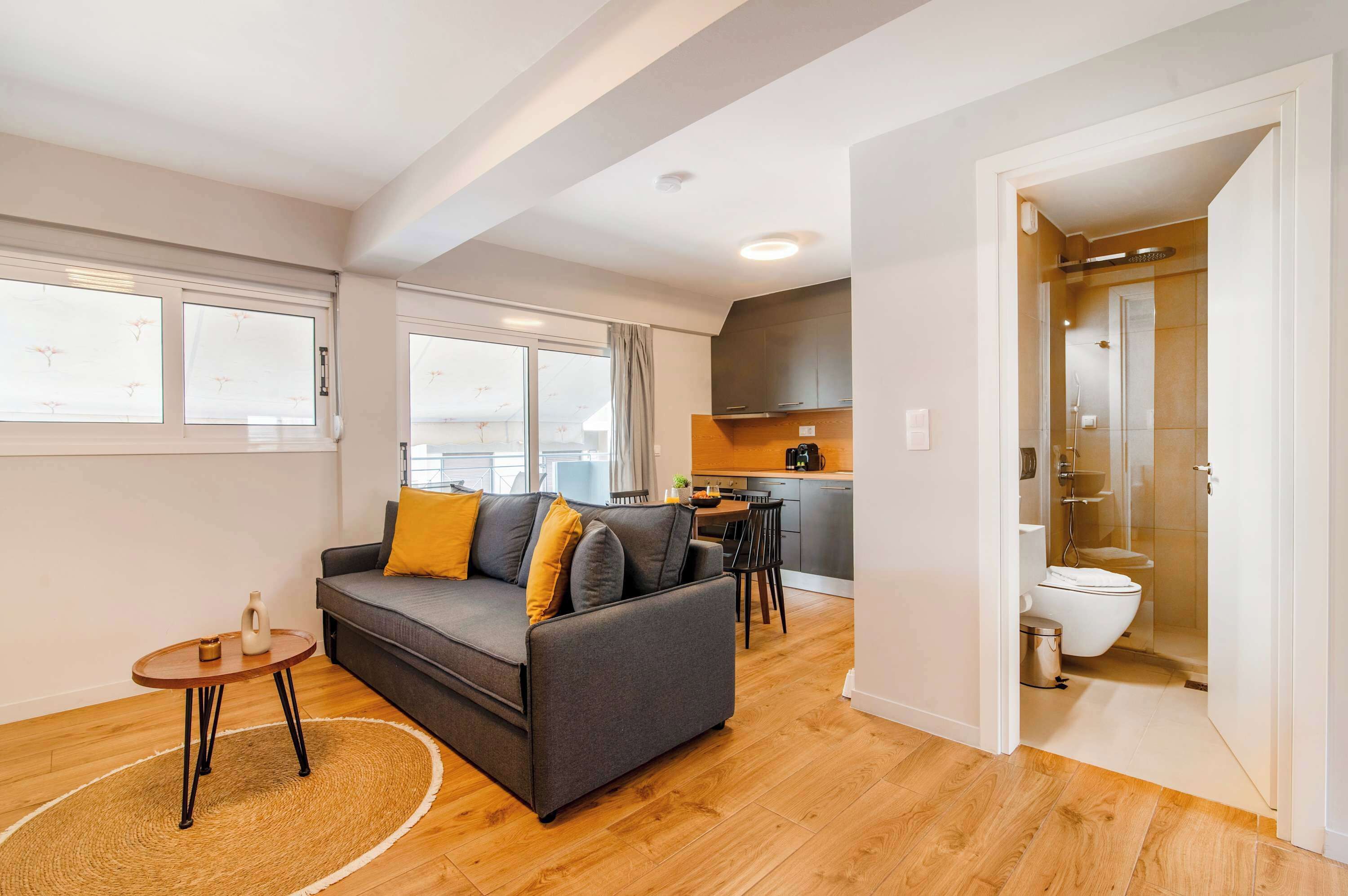 Un apartament modern amb saló, cuina i bany.