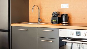 A modern kitchen with a stainless steel refrigerator, a built-in oven, and a coffee maker on the countertop. - Modern Athens Apartment Near Metro Station (Athens)