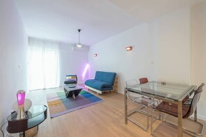Ein modernes Wohnzimmer mit einem Glastisch, einer Couch, einem Couchtisch und einer Lampe.