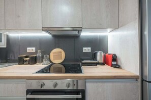 Eine moderne Küche mit eingebautem Herd, Backofen und einem Schneidebrett auf der Arbeitsplatte.