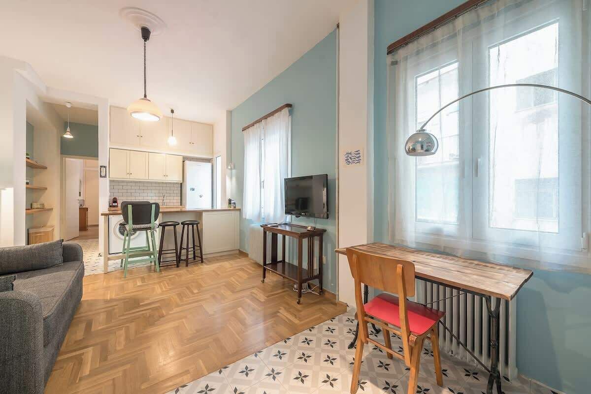 A compact living space with a kitchen, dining area, and a sofa.