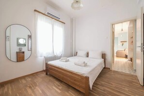 Una camera da letto con un letto in legno, uno specchio rotondo e un termosifone.