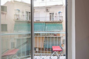A multi-story building with balconies, a red chair, and a ladder. - Zen Hive, in Peaceful Kypseli (Athens)