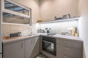 A modern kitchen with a dishwasher, oven, and a window above the sink. - Zen Style, Exarchia (neapoli) (Athens)