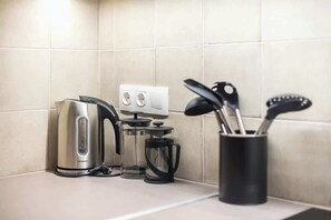 A kitchen counter with a kettle, a coffee maker, and a utensil holder. - Zen Style, Exarchia (neapoli) (Athens)