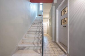 A staircase leading to a landing with a door with decorative glass panels. - Zen Style, Exarchia (neapoli) (Athens)