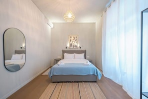 A bedroom with a bed, a mirror, a bedside table, a hanging light fixture, and a wall-mounted artwork. - Zen Style, Exarchia (neapoli) (Athens)