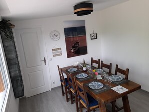 Ein Essbereich mit einem Holztisch, gedeckt für sechs Personen, einer Uhr und einem gerahmten Bild an der Wand.