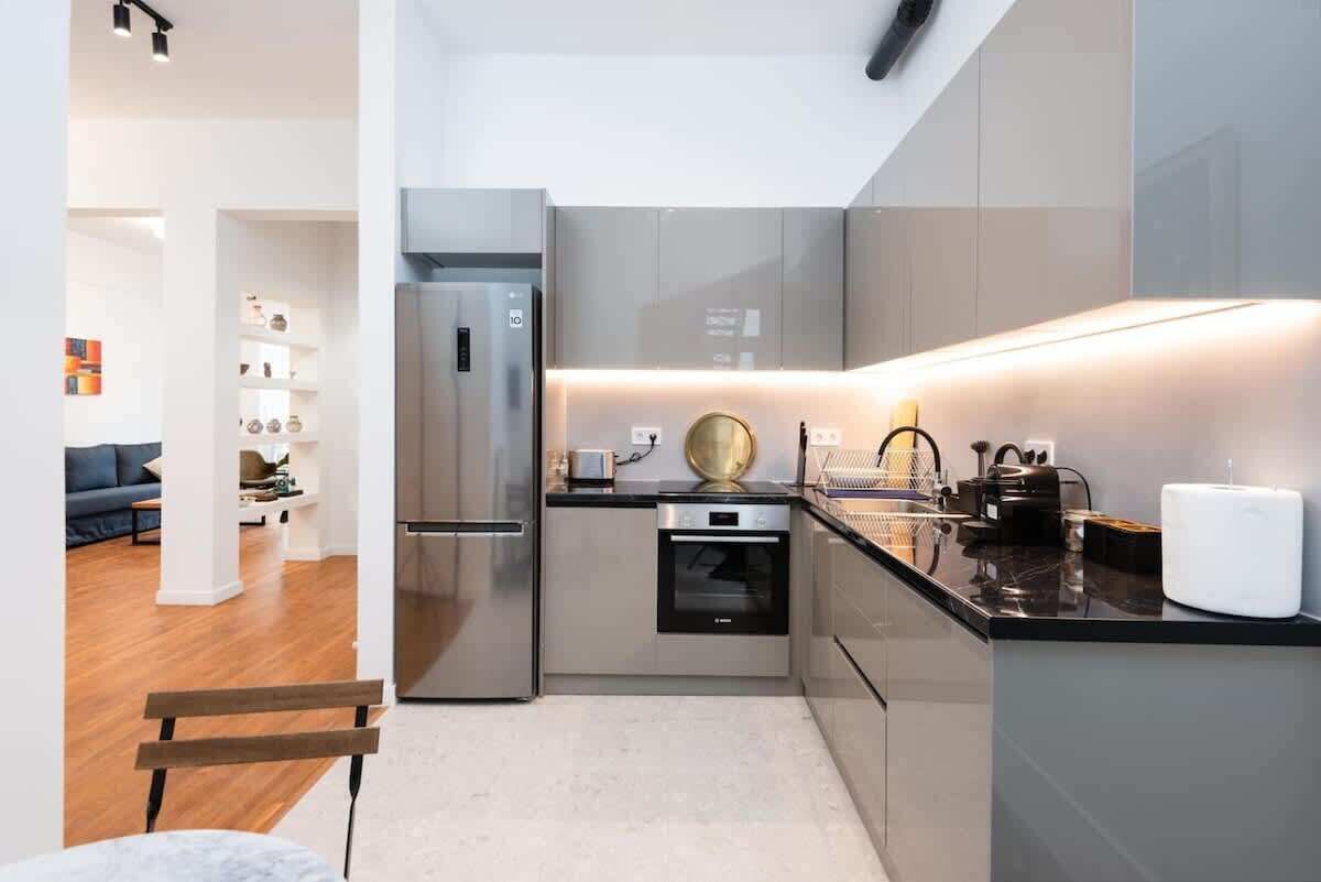 A compact kitchen with a refrigerator, oven, and modern appliances.