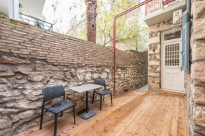 Eine Steinsäule, ein Holzdeck und eine weiße Tür.
