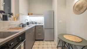 A compact kitchen with a refrigerator, stove, and sink. - Zen Yard, Exarchia (neapoli) (Athens)