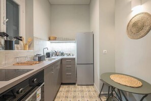 Eine kleine Küche mit Kühlschrank, Herd und Spüle.