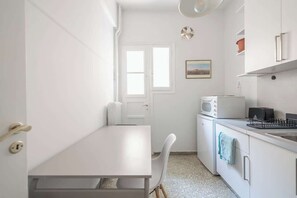 A compact kitchen with white cabinetry, a microwave, and a sink. - Modern Exarcheia Apt w/Balcony, Walk to Cafes & (Athens City)