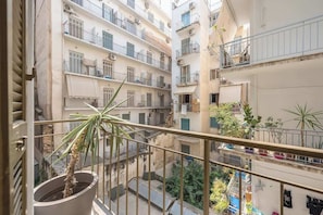 A multi-story residential building with balconies, potted plants, and laundry hanging on lines. - Modern Exarcheia Apt w/Balcony, Walk to Cafes & (Athens City)