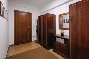 A hallway with a wooden door, a wardrobe, and a mirror. - Zen Sofokleous, Psirri (Athens City)