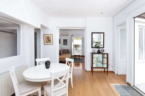 Ein modernes Interieur mit Essbereich, einer Couch, einer Glasschrank und einem großen Fenster.