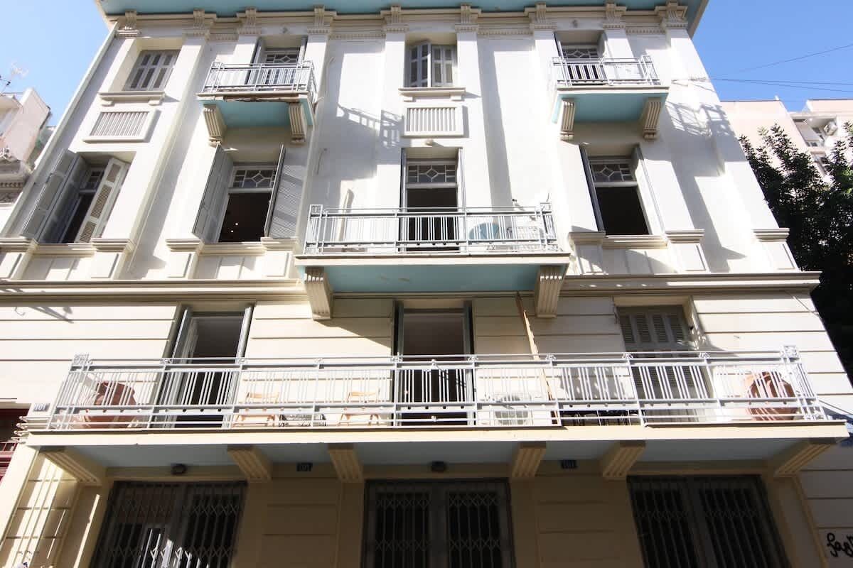 A multi-story building with balconies, windows, and a flat roof.