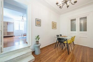 A dining area with a table, chairs, and a potted plant. - Zen Amazing, Exarchia (Athens)