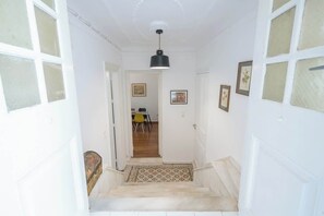 A staircase leading to a room with a patterned floor, white walls, and a black pendant light. - Zen Amazing, Exarchia (Athens)