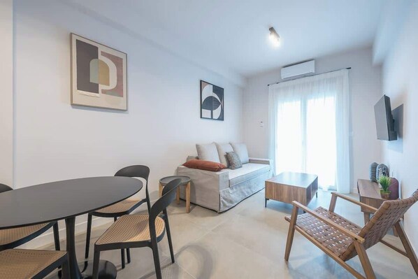 Een moderne woonkamer met een bank, een eettafel en stoelen.