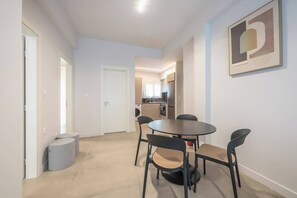 Eine moderne Küche mit Essbereich, einem runden Tisch und Stühlen.