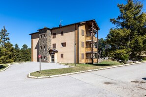 Ein mehrstöckiges Gebäude mit einer steinernen Fassade, hölzernen Balkonen und blauem Himmel.
