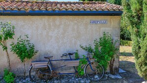 Ein Fahrrad, das an einer Wand geparkt ist, mit einem Schild, auf dem 'COUPILLE' steht.