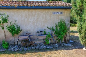 Ein Fahrrad, das an einer Wand geparkt ist, mit einem Schild, auf dem 'COUPILLE' steht.