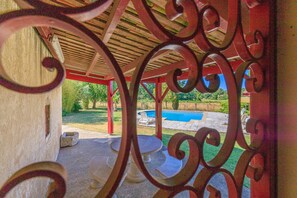 A covered outdoor area with a pool, surrounded by greenery. - L'Etable de Sauvignac - Avec piscine privée (Sauvignac)