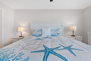 Un dormitorio con una cama, dos mesitas de noche y un tocador.